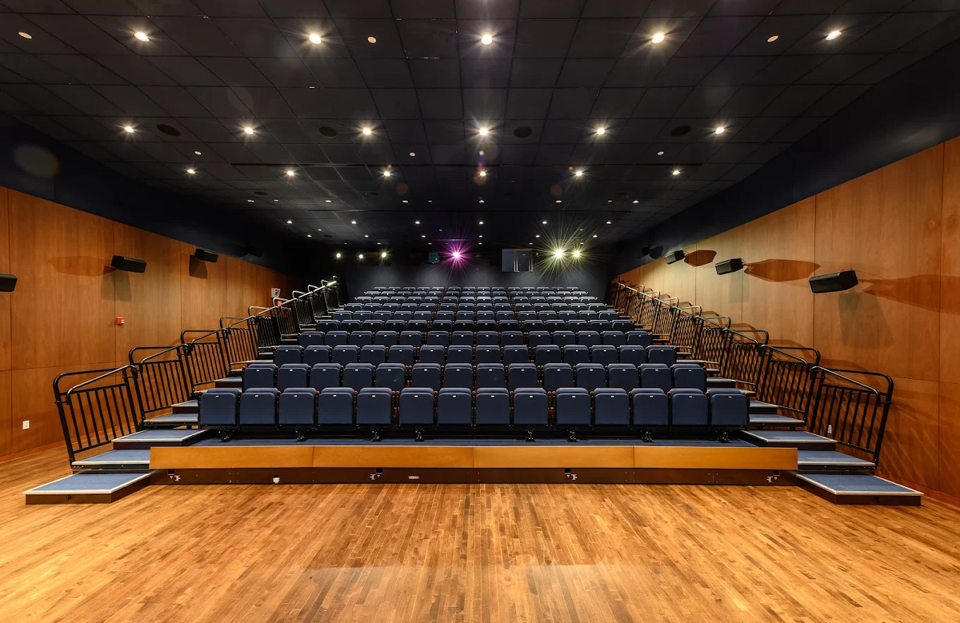 Cafritz Hall from the seats, wood walls and the gold-framed screen